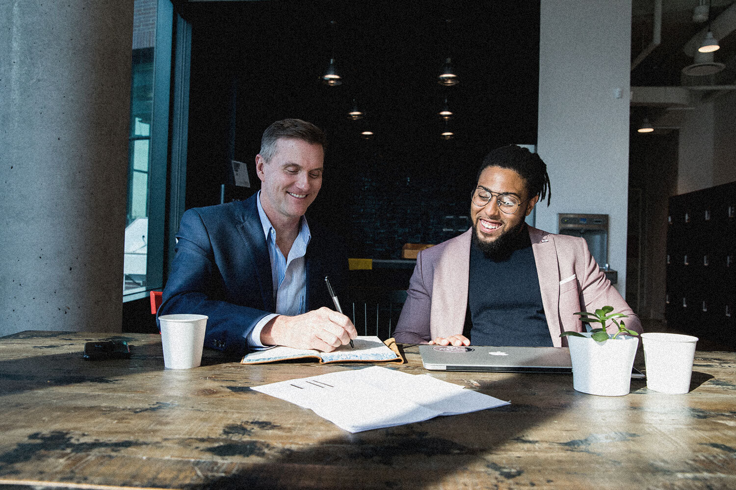 Corey and a client working through a brand strategy at a table, laughing
